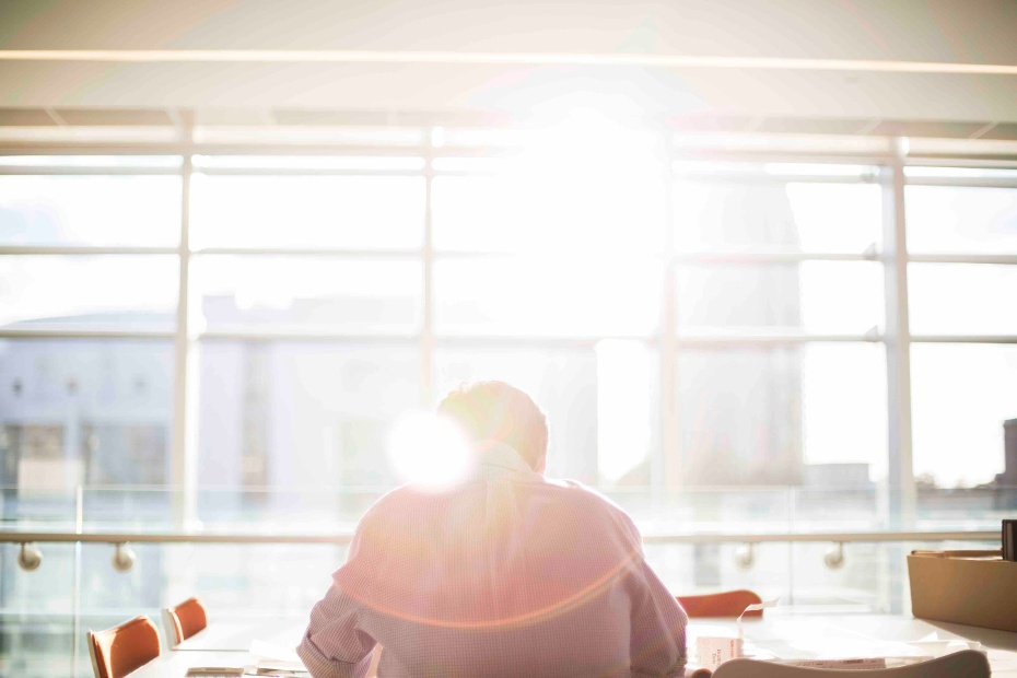 Man working at conference desk with sun shining through window